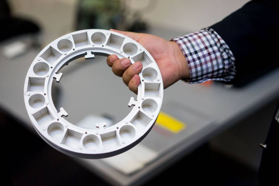 Hand holding a round-shaped metal object.