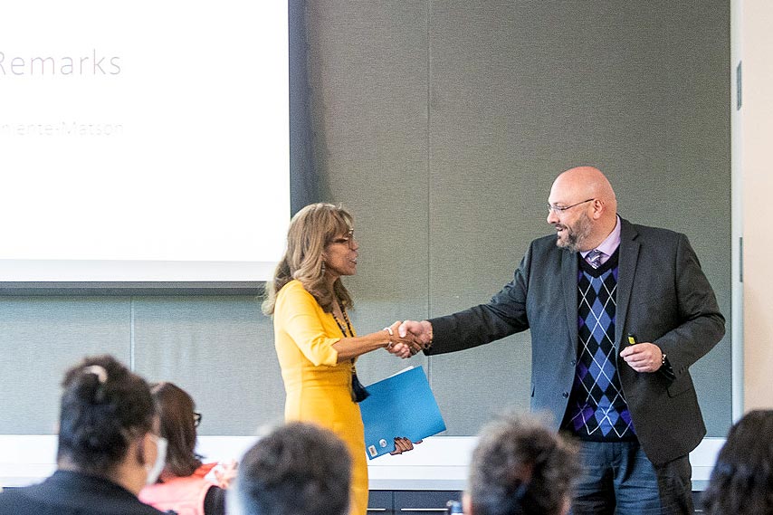 President Teniente-Matson shaking hands with the dean of College of Business.